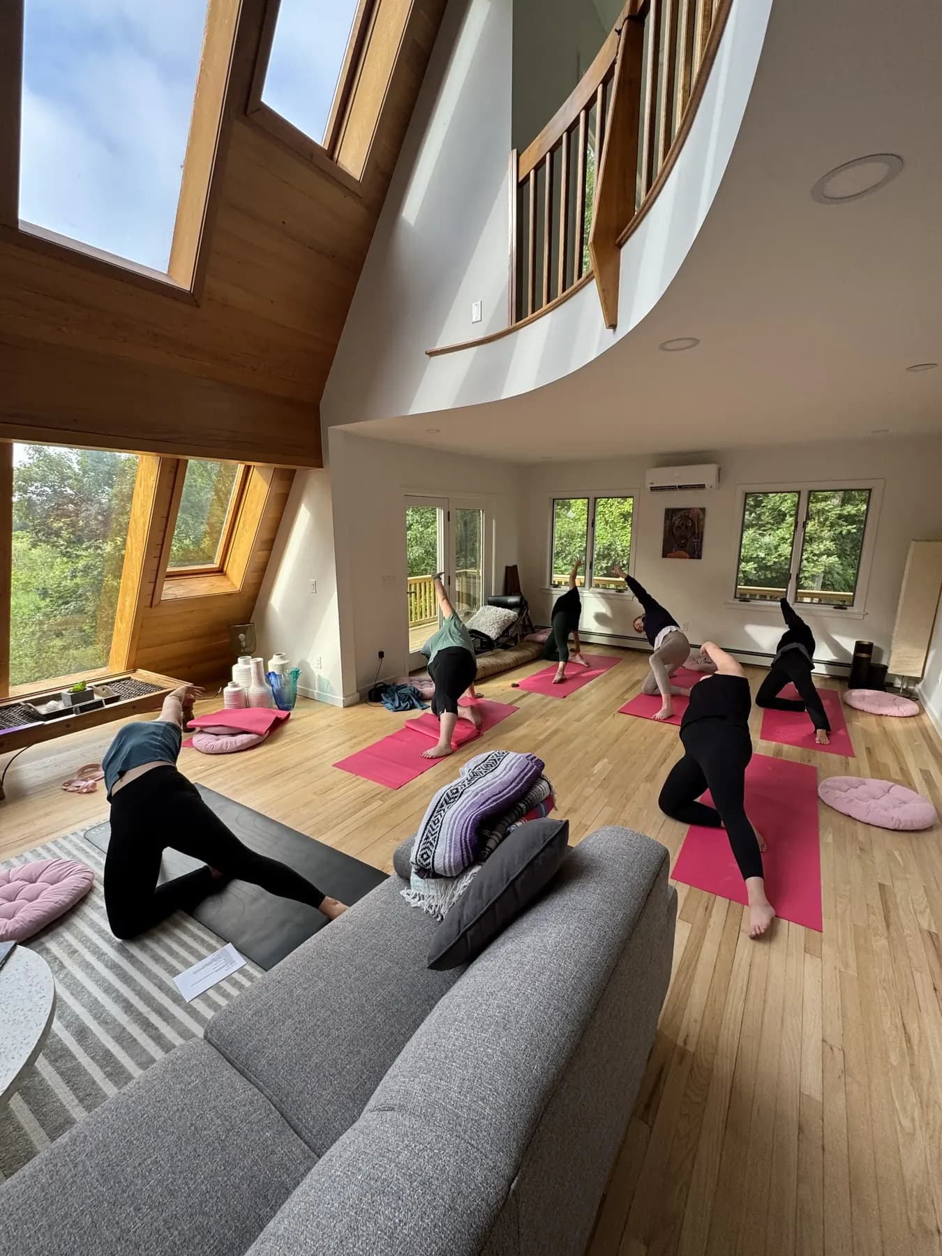 Women practicing yoga together in a bright summer retreat house