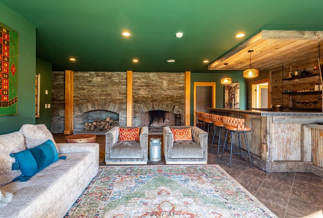Cozy lounge with twin stone fireplaces and a private bar